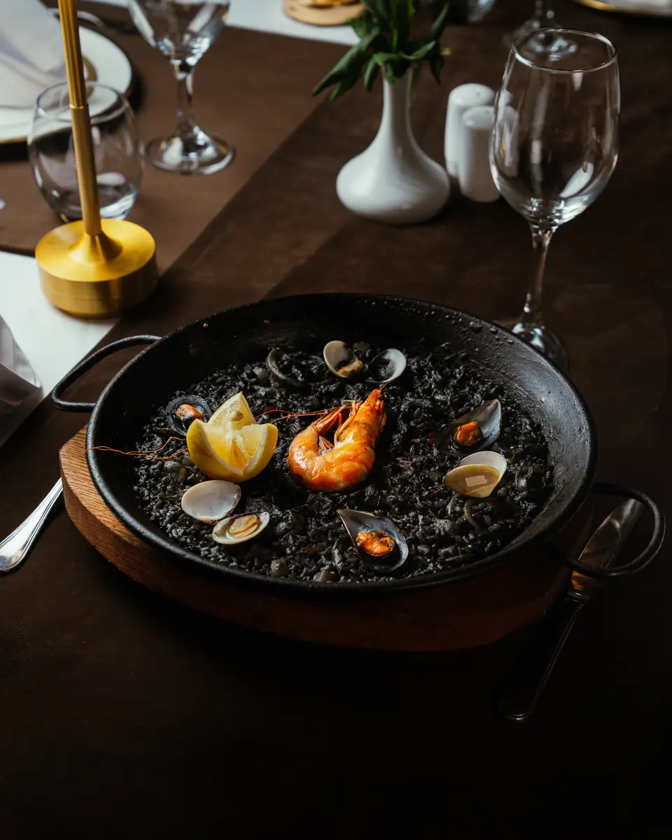 Paella au riz noir, aux crevettes et aux palourdes
