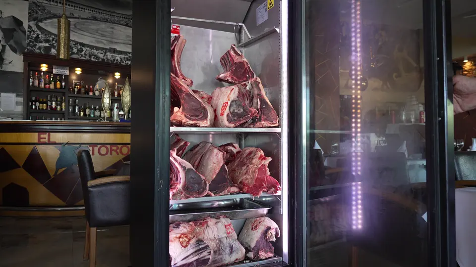 Pièces de bœuf avec os exposées dans une vitrine réfrigérée