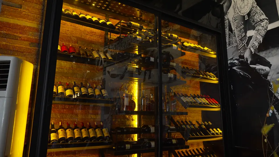 La cave à vins éclairée derrière sa vitre