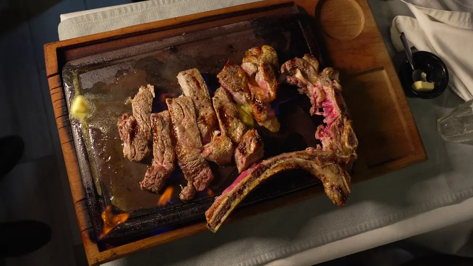 Bœuf tranché avec l’os de la côte, sur un plateau en bois