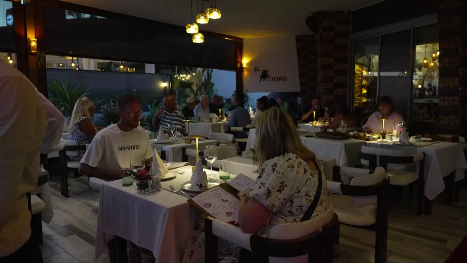 Des clients consultent la carte à leur table sur la terrasse