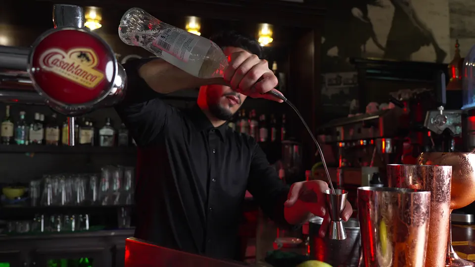 Le barman verse une boisson depuis le shaker