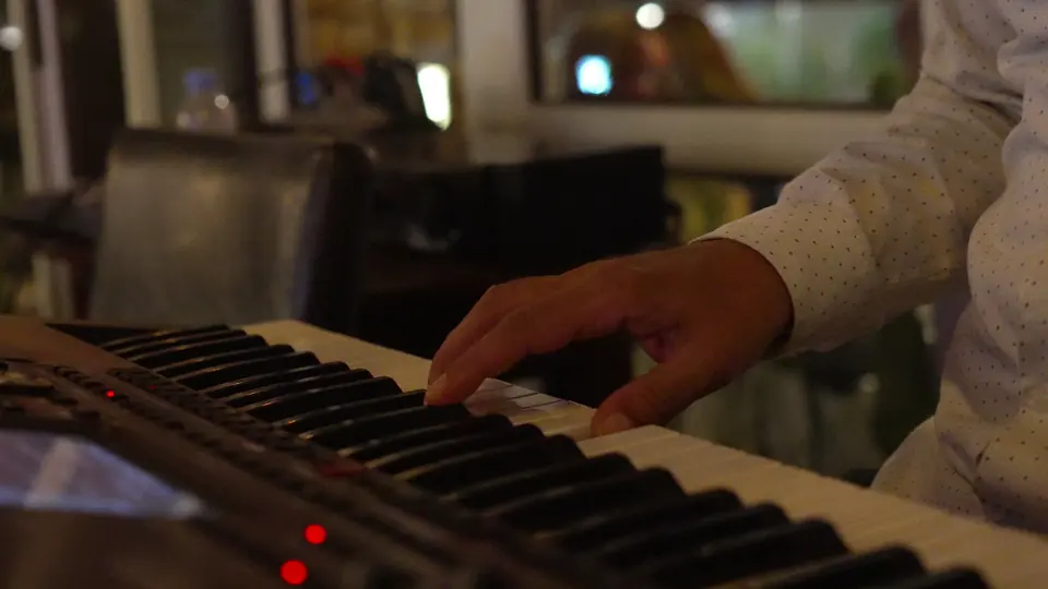 Les mains d’un musicien sur un clavier pendant le dîner