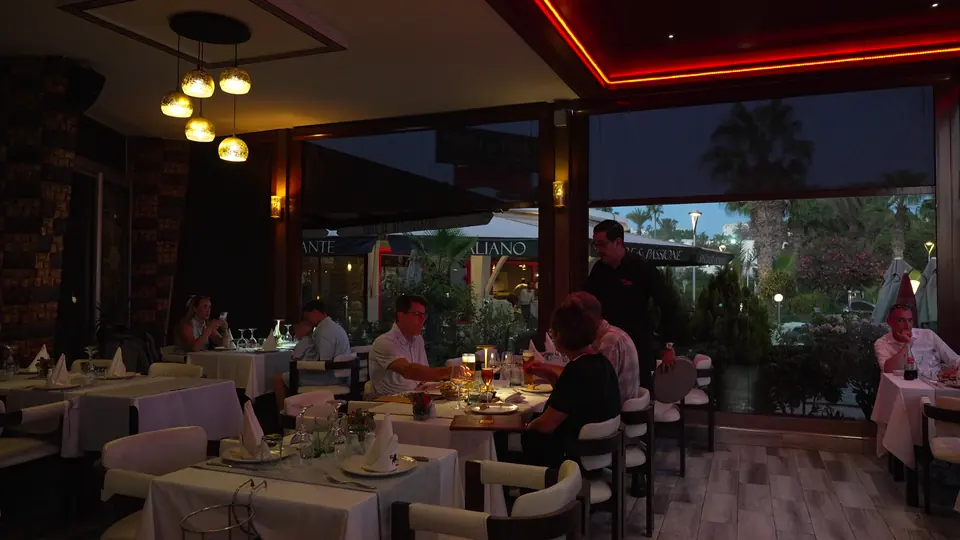 Des convives dînent sur la terrasse, le soir
