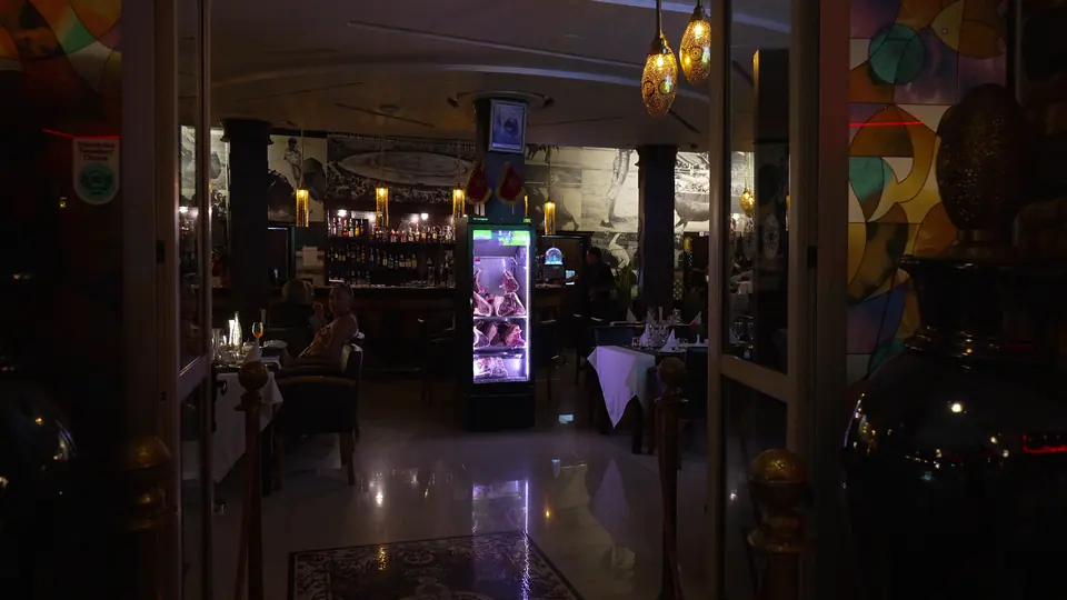 La salle de nuit, avec la vitrine de bœuf éclairée et le bar au fond