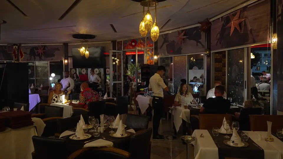 La salle de nuit, un serveur entre les tables occupées