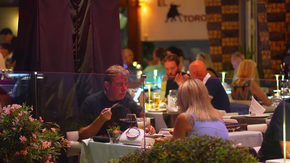 Des convives à table sur la terrasse, de nuit