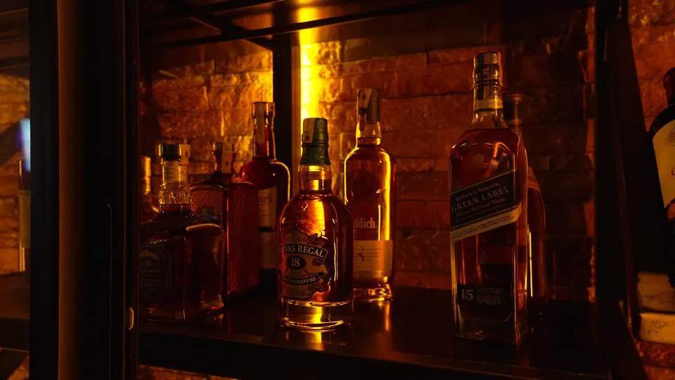 Bouteilles de whisky sur une étagère éclairée du bar