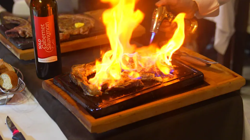 Un steak flambé sur une planche en bois
