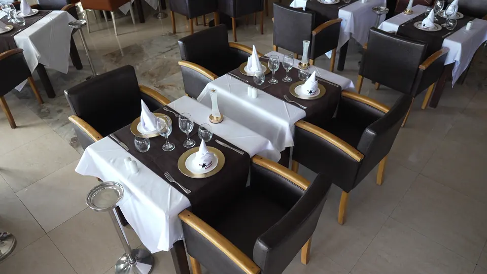 Table dressée de lin blanc, serviettes pliées en cône