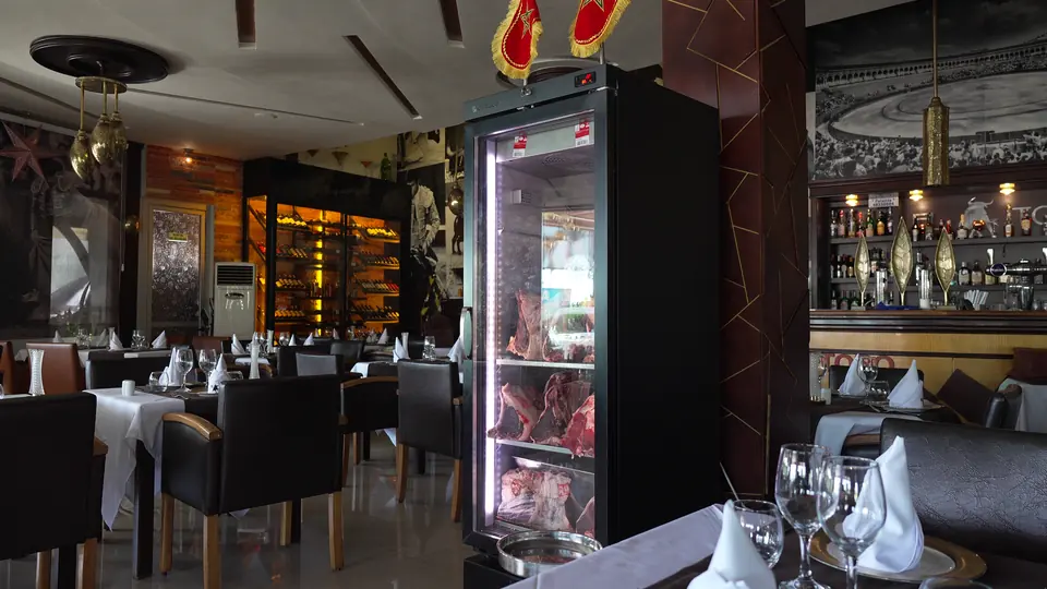 La salle et, au centre, une vitrine réfrigérée qui présente des pièces de bœuf