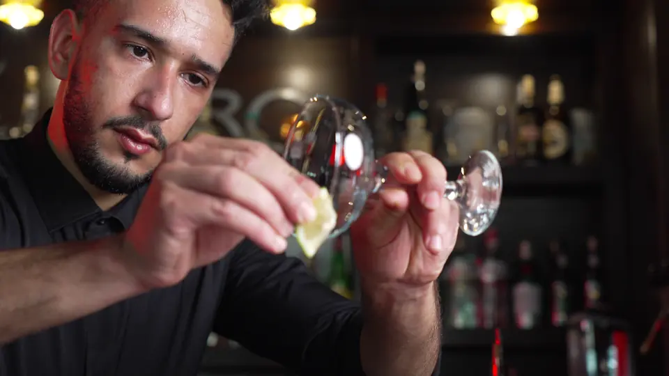 Le barman garnit un verre de citron vert